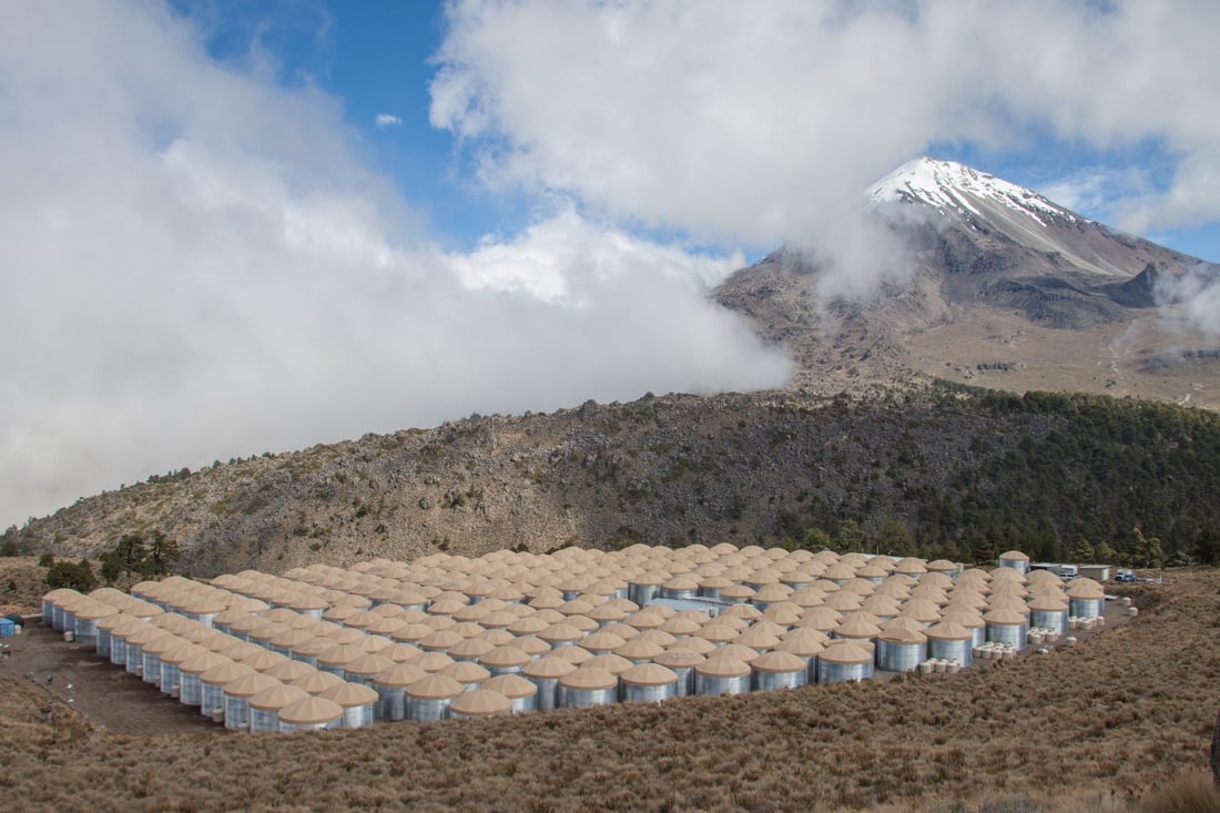 The water-Cherenkov tanks of the HAWC observatory below the Pico de Orizaba volcano in Mexico
