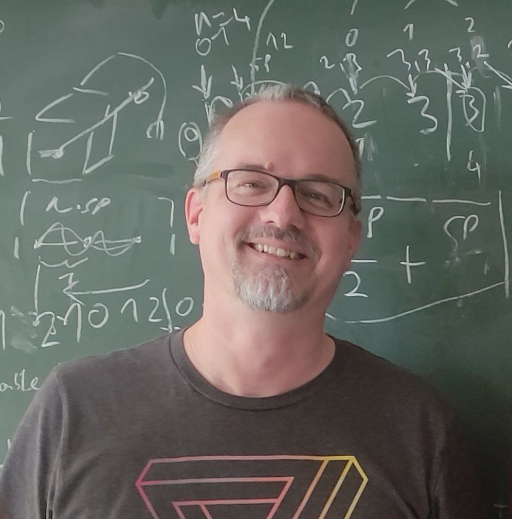 Portrait of Fabian Schüssler in front of a chalkboard